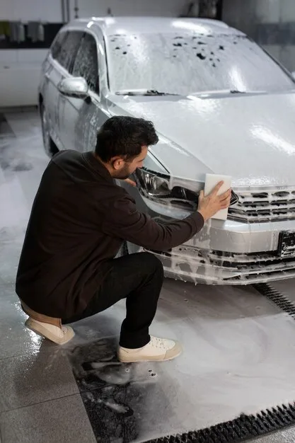 man-washing-car-headlight_23-2149316431